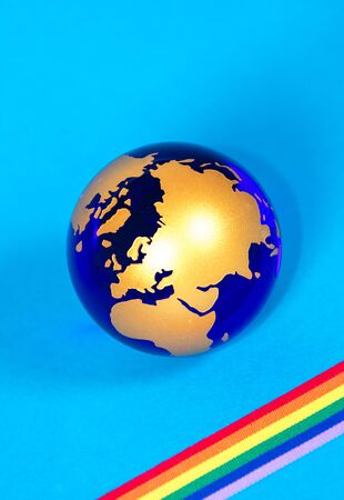 The planet Earth along with a colorful rainbow colored ribbon which signifies many things, such as the Coronavirus pandemic.の素材 [FY310143524301]