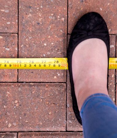 With the World in stage of a Pandemic, due to Coronavirus, the social distance advised by many countries is 2m (200cm). Here is a foot, standing at the 2 meter mark.の写真素材