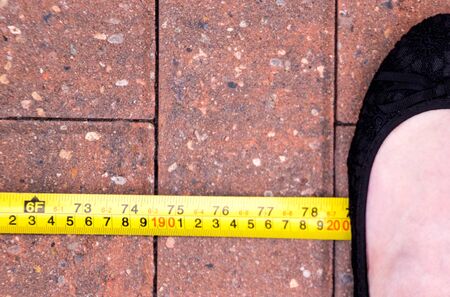 With the World in stage of a Pandemic, due to Coronavirus, the social distance advised by many countries is 2m (200cm). Here is a foot, standing at the 2 meter mark.の写真素材