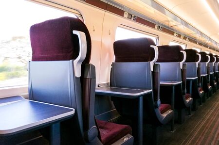 A view along the many rows of empty First Class seating onboard a train. No passengers or staff seen...