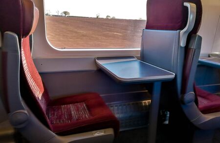 A view along the many rows of empty First Class seating onboard a train. No passengers or staff seen...