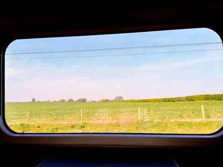 A view from a passenger window seat table as the train races through the British countryside.