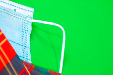 A surgical mask wrapped up in tartan Christmas wrapping paper.