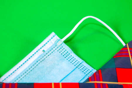 A surgical mask wrapped up in tartan Christmas wrapping paper.の写真素材