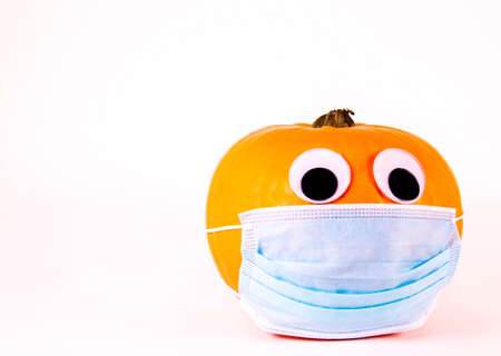 A Halloween pumpkin, with eyes, wearing a surgical mask during the virus pandemic.の写真素材