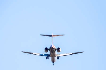 A large passenger aircraft seen from the ground up, high above ground level. Carrying passengers of business and leisure around the world.の写真素材