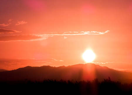 One of the beautiful sunsets on the Sicilian landscapes. The sun setting fast behind the hills of...