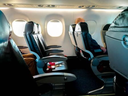 A view along one of the rows on board an airline. The seats empty due to the lack in travel with the virus pandemic.の写真素材