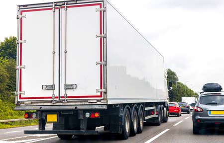 A large HGV vehicle traveling along one of the main road routes of the United Kingdom, on a summer's day. Taking goods to and from their suppliers and customers.の写真素材