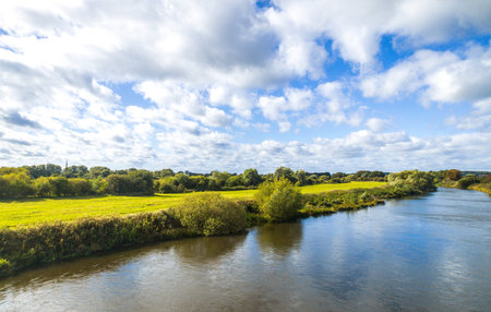 A view across the beautiful landscape of British countryside. The view taken from a speeding train passing up and down the country.の写真素材