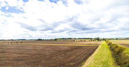 A view across the beautiful landscape of British countryside. The view taken from a speeding train passing up and down the country.の写真素材