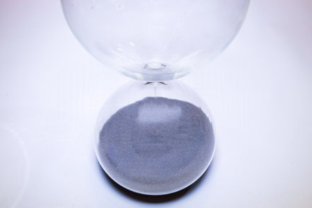 A large egg timer viewed from above that has run out of time, the sand sitting in the bottom.