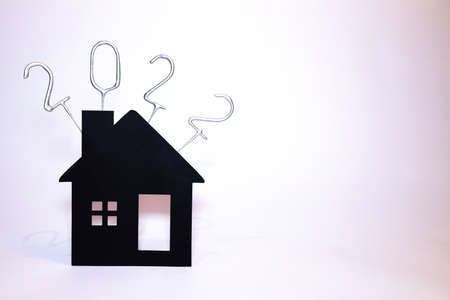 A single house with sparklers, unlit, sticking out of the top with the year 2022 in numbers.