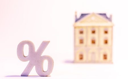 A property stands side by side with an interest rates / percentage sign close by, against a white background.の写真素材