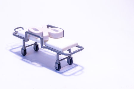 A percentage symbol sits on a hospital bed / stretcher to signify interest rates or the hospital crisis. Taken against a white background.の写真素材