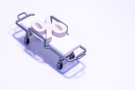 A percentage symbol sits on a hospital bed / stretcher to signify interest rates or the hospital...