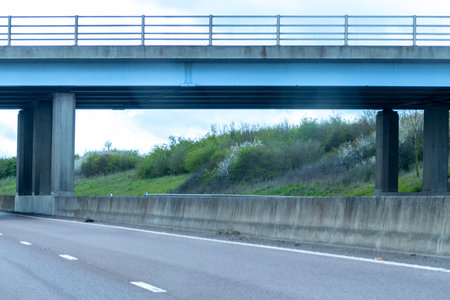 A typical British road leading under a small bridge. The road leading round to the right in the...