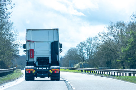 A large HGV vehicle traveling along one of the main road routes of the United Kingdom, on a summer's day. Taking goods to and from their suppliers and customers.の写真素材