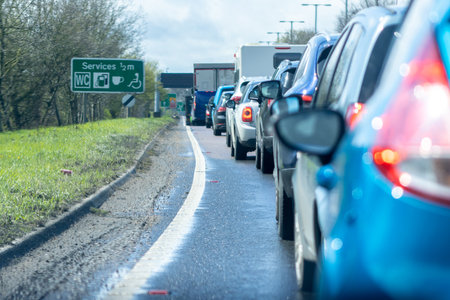 A line of vehicles wait inline, in a traffic jam during rush hour on one of the many British roads.