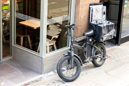 A specially designed bike with a carrier on the rear made to take takeaway food to the next customer sitting against the restaurant wall.の写真素材