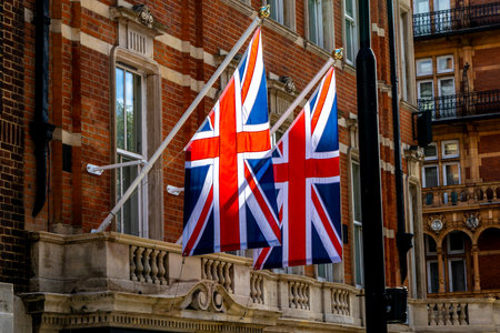 The iconic colours of the Union Jack flag hanging from the side of a building for support or as a British residence.の写真素材