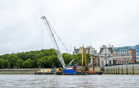 Equipment and materials are lifted by a large crane on and off the dock or vessels in order to safely move them across.の写真素材