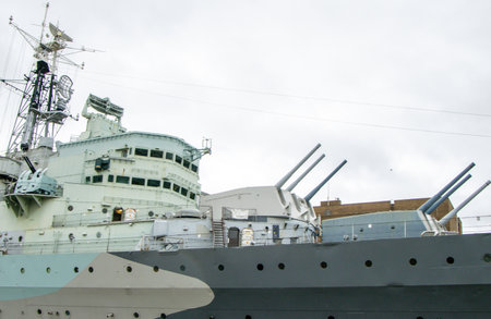 The River Thames, in London, with a large Warship dockside for people all around to see and enjoy.の写真素材