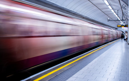 A view from a train station platform as a passenger train flies past at high speed.の写真素材