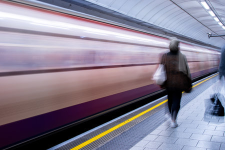 A view from a train station platform as a passenger train flies past at high speed.の写真素材