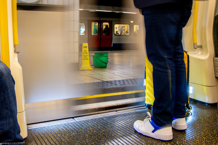A London Underground train either arriving or departing as the doors open or close ready to pick up or drop off it's passengers.の写真素材