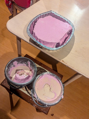 Hand casts made from alginate powder that has set to contain hand formations. Memories made from casting powder then poured into the pink casts.の写真素材
