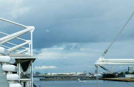 A large commercial aircraft taking off, flying over the Royal Victoria Dock.の写真素材