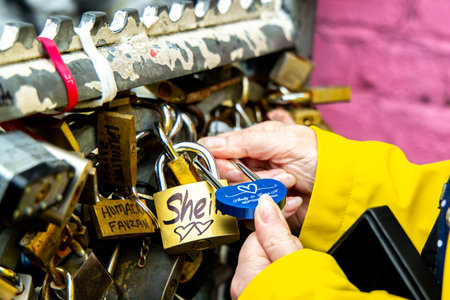 A sign of love or friendship with a padlock that has been locked onto a metal fenceline and left for...