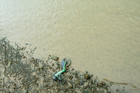 A rented electric bike that has been thrown into the River Thames, only visible due to the tide being out.の写真素材