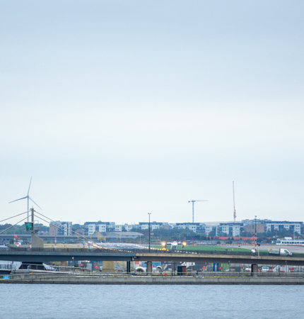 A large commercial aircraft taking off from London City Airport, in the United Kingdom, flying over the Royal Victoria Dock.の写真素材