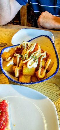 Spanish style cooked potatoes freshly cooked with salsa and mayonnaise sauce to enjoy.の写真素材