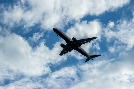 A passenger aircraft passing overhead as it either comes into land or has just taken off from an airport.の写真素材
