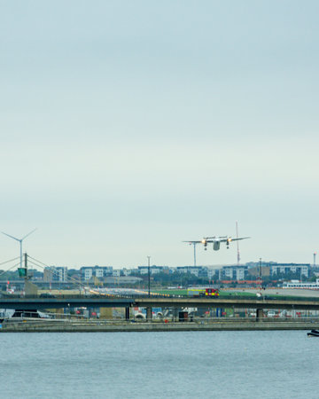 A large commercial aircraft taking off from London City Airport, in the United Kingdom, flying over the Royal Victoria Dock.の写真素材