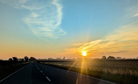 Awe inspiring colours as the sun goes down behind a lovely landscape, seen from a country road, within the United Kingdom.の写真素材