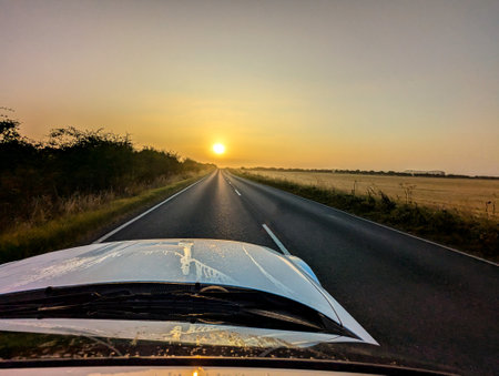 Awe inspiring colours as the sun goes down behind a lovely landscape, seen from a country road, within the United Kingdom.の写真素材