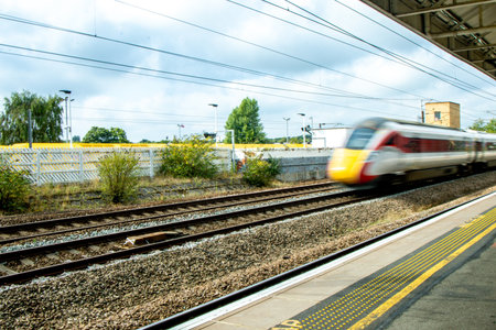 A view from a train station platform as a passenger train flies past at high speed.の写真素材