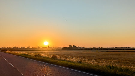 Awe inspiring colours as the sun goes down behind a lovely landscape, seen from a country road, within the United Kingdom.の写真素材