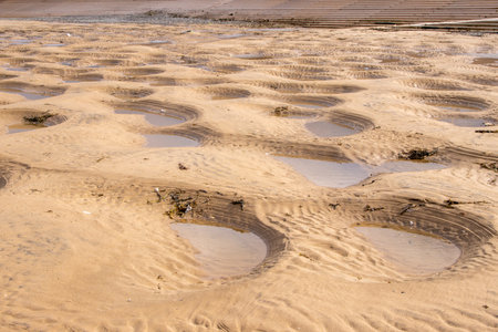 Small pools of water are created in small pits along the coast of a large beach, nature's creations with various weathers and tides.の写真素材