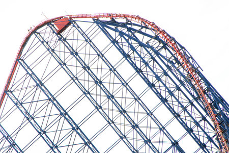 A rollercoaster is one of the best adrenaline junkie activities to do. Here seen a large rollercoaster structure with twists and turns for people to enjoy within a theme park.の写真素材