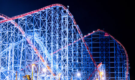 A rollercoaster is one of the best adrenaline junkie activities to do. Here seen a large rollercoaster structure with twists and turns for people to enjoy within a Theme Park.の写真素材