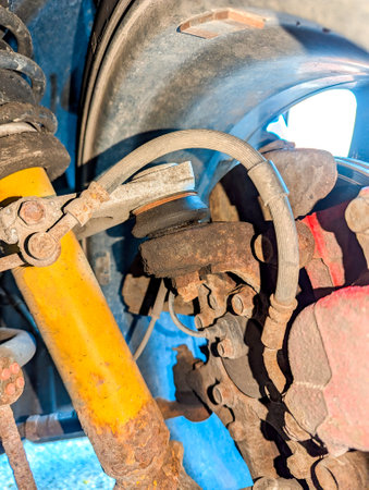 The underbody of a vehicle that is a little rusty, with a close up view of the suspension that enables the car to have a smoother ride.の写真素材