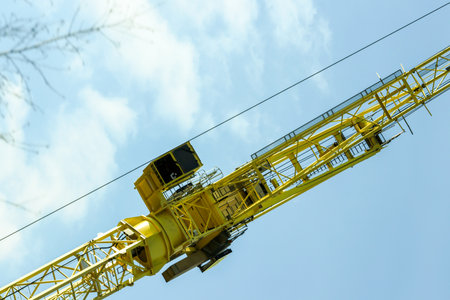 Tall yellow industrial cranes towering above the ground ready to lift or drop off it's next load.の写真素材