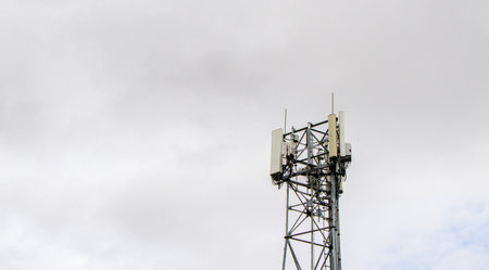 A communications tower with several technological items strapped to it and to provide a signal to all those within the reach of the tower's signal.の写真素材