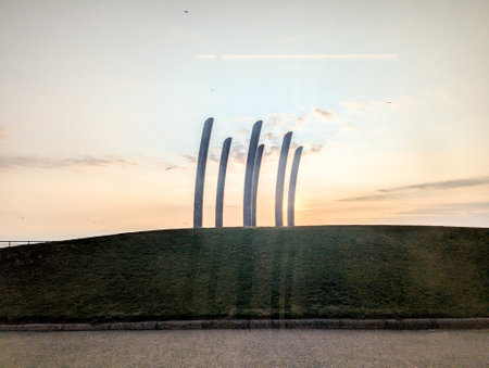 A clear and warm summer's evening as the sun goes down everything is silhouetted against the warm colours of the sky as the sun disappears.の写真素材