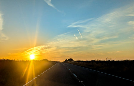 Awe inspiring colours as the sun goes down behind a lovely landscape, seen from a country road, within the United Kingdom.の写真素材